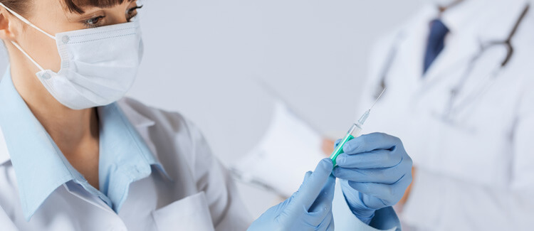 Female doctor holding syringe with injection