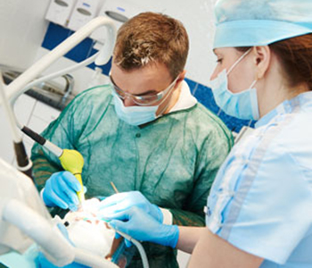 Dentist and assistant working with microscope