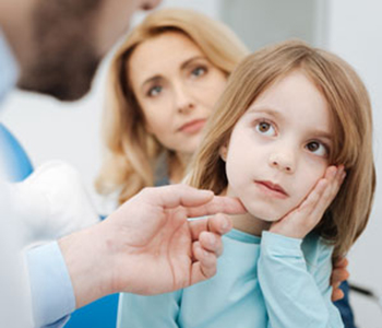 Little upset child telling the doctor about the pain