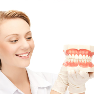 Doctor smiling and holding big jaws denture