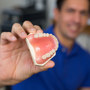 Dental technician presenting dental prosthesis