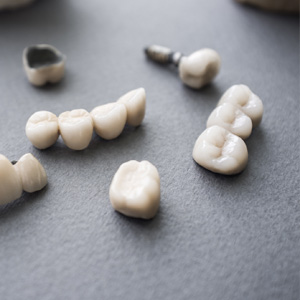 Ceramic dentures and crowns on gray background