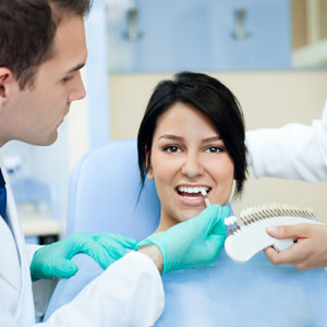 Dentist choosing color teeth from palette for tooth color