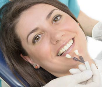 A dentist showing porcelain teeth to patient
